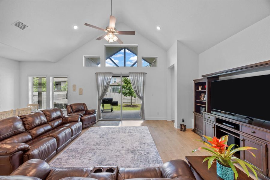 A spacious living room features vaulted ceilings, rich hardwood flooring, and sliding glass doors that open to the outdoors. A spacious living room features vaulted ceilings, rich hardwood flooring, and sliding glass doors that open to the outdoors.