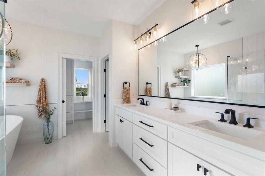 Full bathroom featuring double vanity, a freestanding tub, a shower stall, and a chandelier Full bathroom featuring double vanity, a freestanding tub, a shower stall, and a chandelier