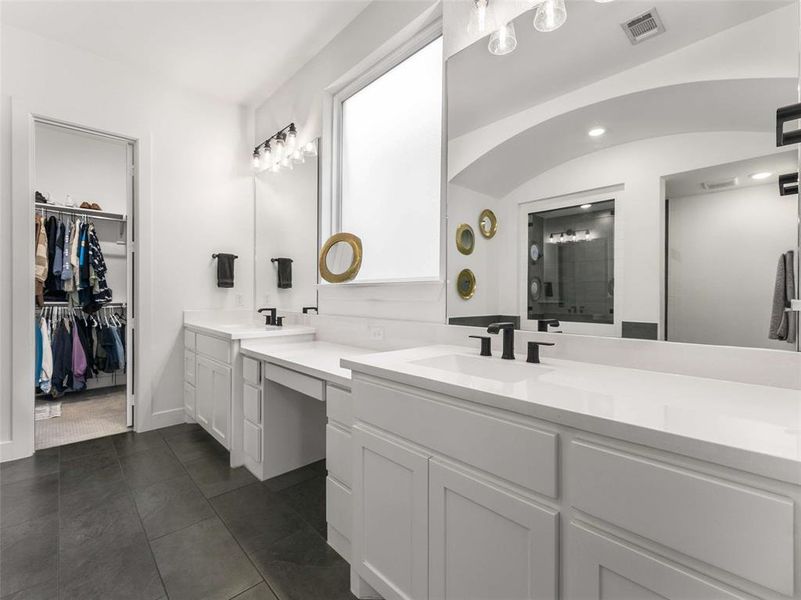 The ensuite primary bathroom features an extral long vanity and a large walk in closet