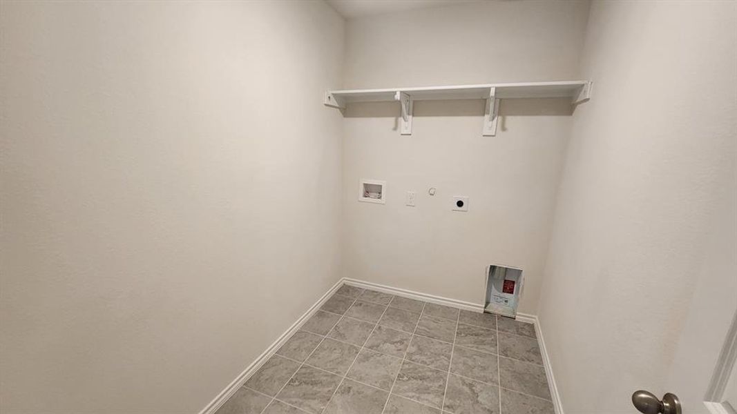 Dedicated utility space featuring tile flooring and built-in shelving Dedicated utility space featuring tile flooring and built-in shelving