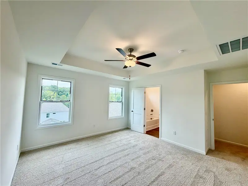 An elegant tray ceiling and plush carpeting define