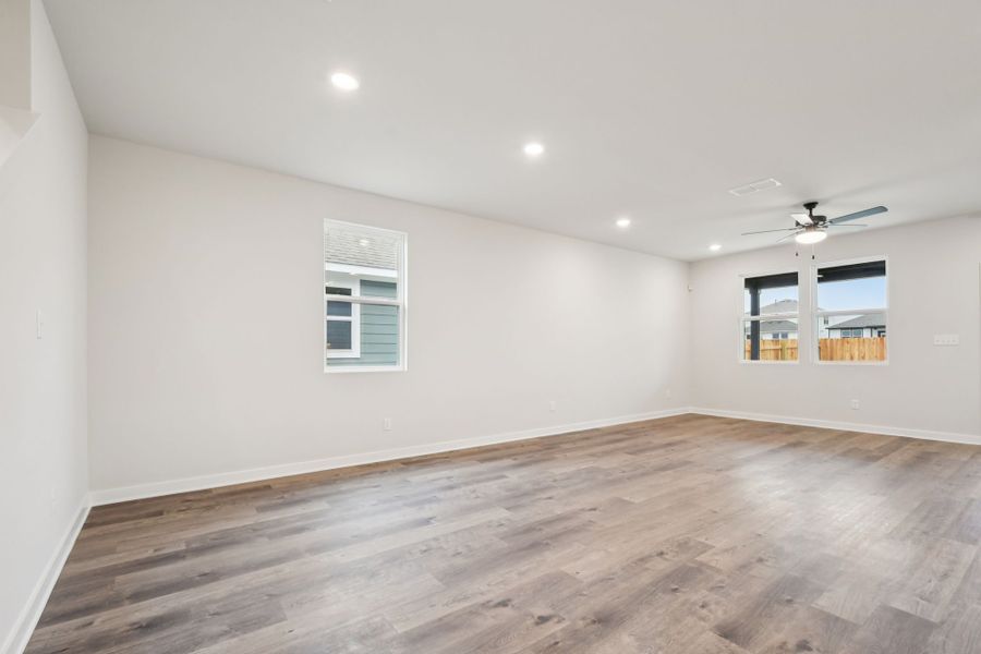 A room with a wood floor and a wood floor with a ceiling fan.