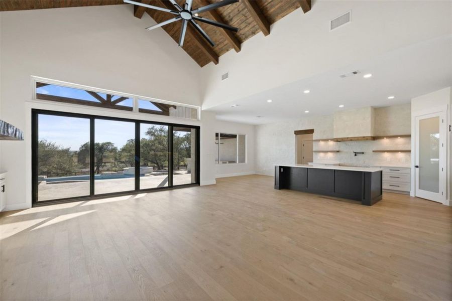 A spacious great room features vaulted ceilings, wide plank wood flooring, and a chef's kitchen with an island. A spacious great room features vaulted ceilings, wide plank wood flooring, and a chef's kitchen with an island.
