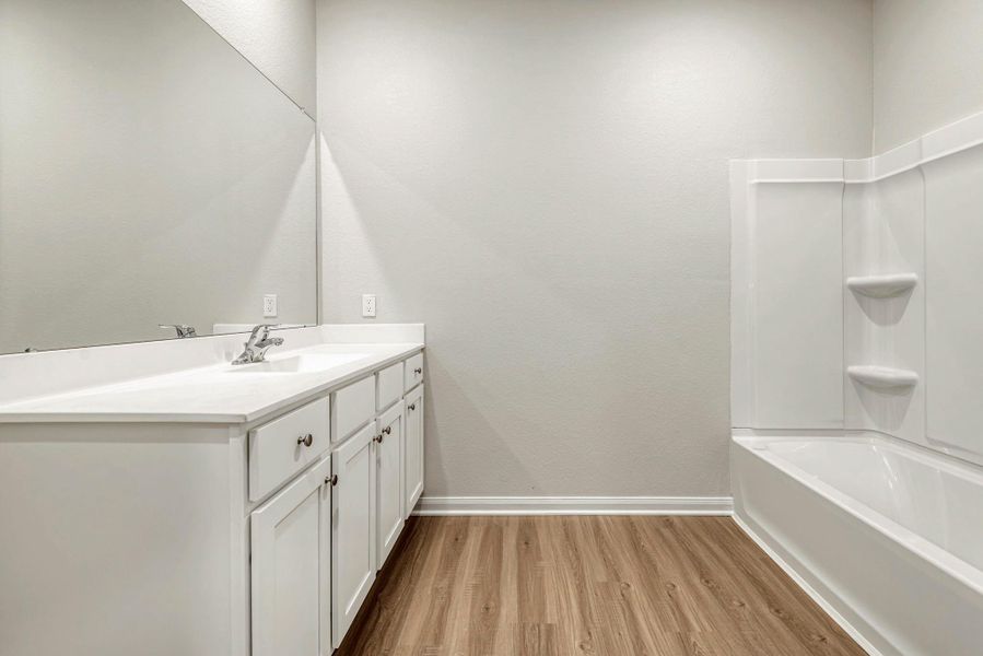 The spacious, primary en-suite bathroom with a shower/tub combo.