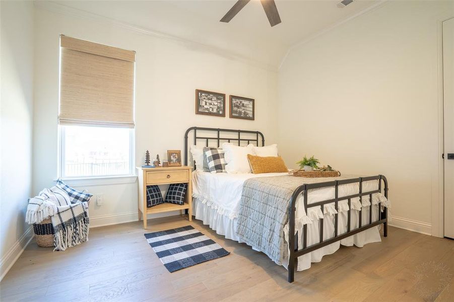 Bedroom with wood finished floors, ceiling fan, lofted ceiling, and ornamental molding Bedroom with wood finished floors, ceiling fan, lofted ceiling, and ornamental molding