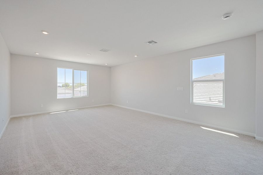 A room with a white wall and windows.