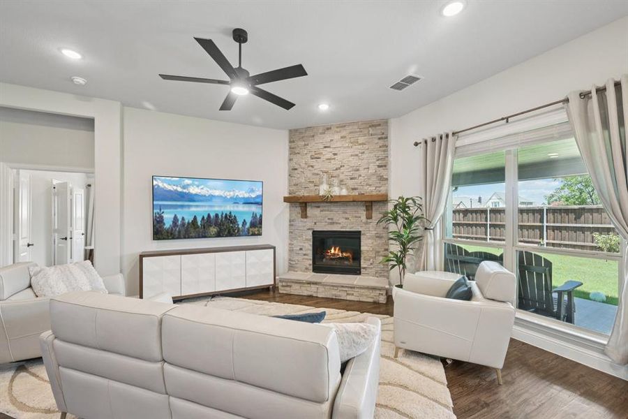 Living room featuring ceiling fan, wood finished floors, a fireplace, and recessed lighting Living room featuring ceiling fan, wood finished floors, a fireplace, and recessed lighting