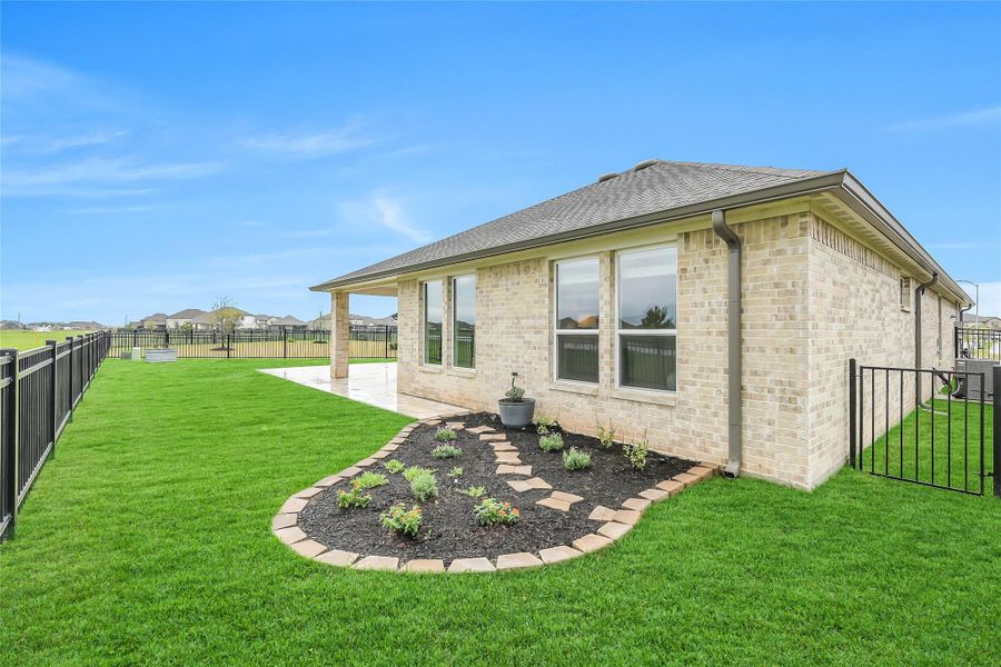 Well-maintained backyard featuring manicured landscaping and a full brick exterior, combining durability with timeless curb appeal.
