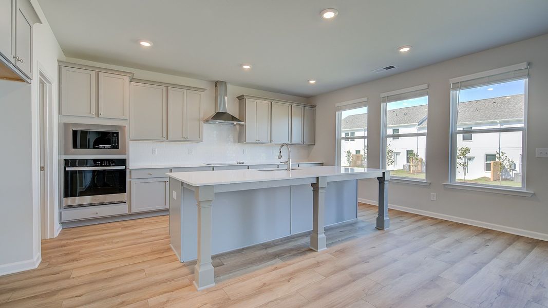 Open Ridgewood kitchen with bright modern features and oversized island with seating at Bowers Farm.