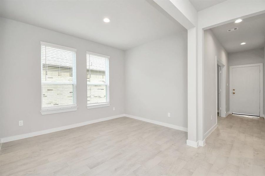 Create lasting memories with your family and friends at the dining table! This expansive dining room showcases sophisticated flooring, custom paint, and seamlessly connects to the family room and kitchen, providing an open and inviting atmosphere. Example photo of completed home with similar plan. Actual may vary.