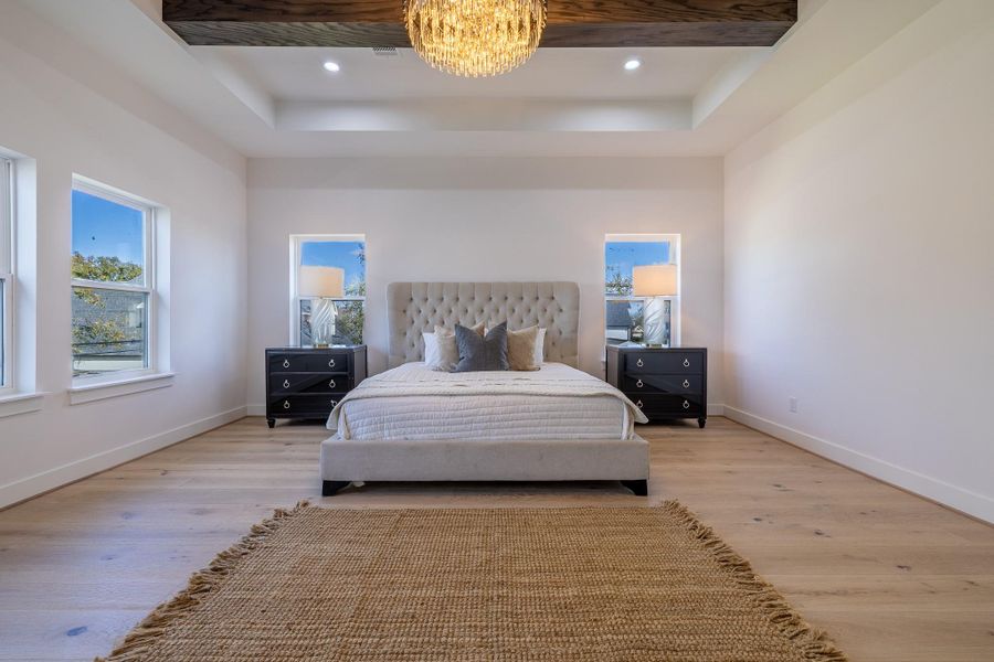 Alternate view of the spacious primary suite showcasing beam ceiling detail, generous scale, and a calm, retreat-like atmosphere.