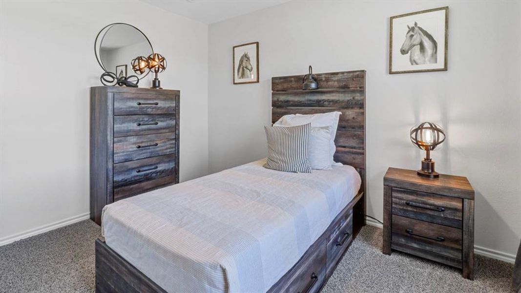 Bedroom with dark colored carpet and baseboards