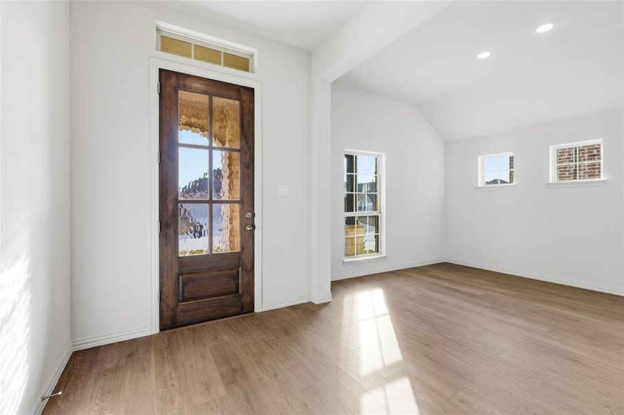 Entryway with light wood finished floors, vaulted ceiling, and recessed lighting Entryway with light wood finished floors, vaulted ceiling, and recessed lighting