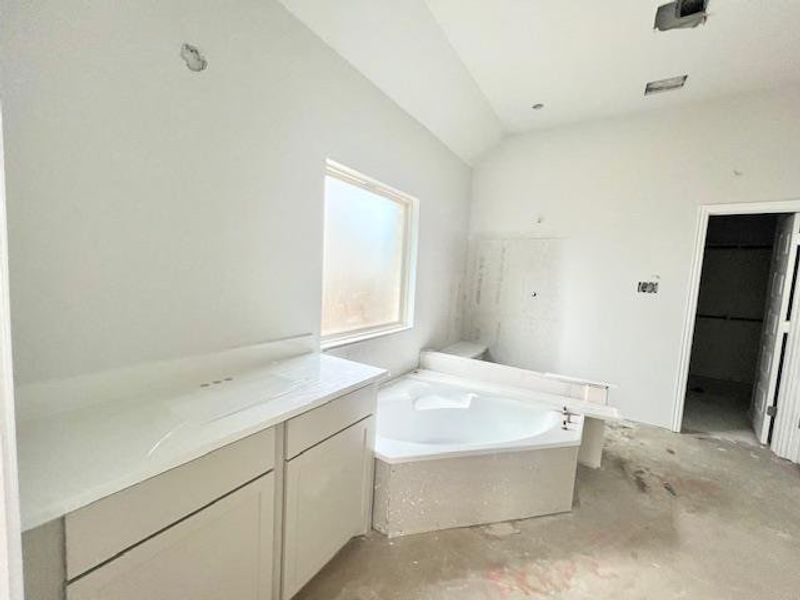 Full bathroom with a garden tub, vanity, and unfinished concrete floors Full bathroom with a garden tub, vanity, and unfinished concrete floors