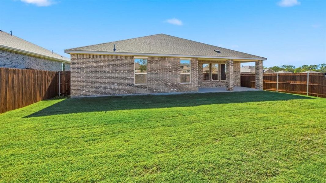 Rear view of property with brick siding, a fenced backyard, a patio area, and roof with shingles Rear view of property with brick siding, a fenced backyard, a patio area, and roof with shingles