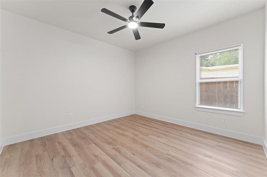 Spare room with light wood-type flooring, ceiling fan, and baseboards Spare room with light wood-type flooring, ceiling fan, and baseboards