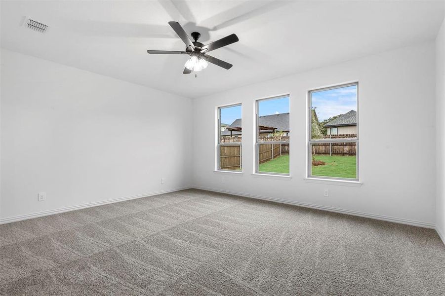 Carpeted spare room featuring ceiling fan