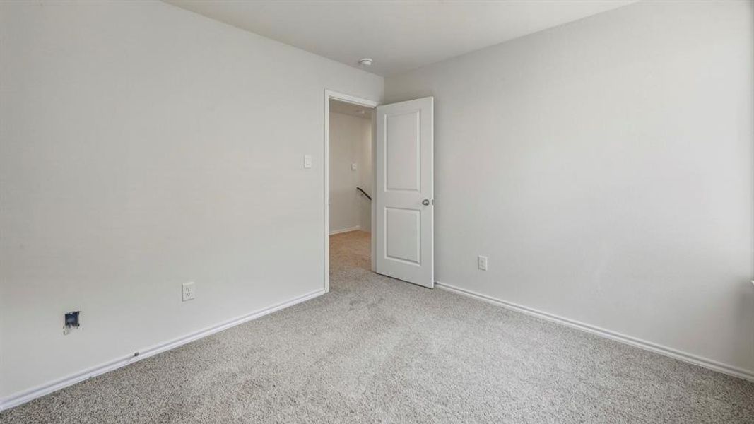 Unfurnished room featuring light carpet and baseboards