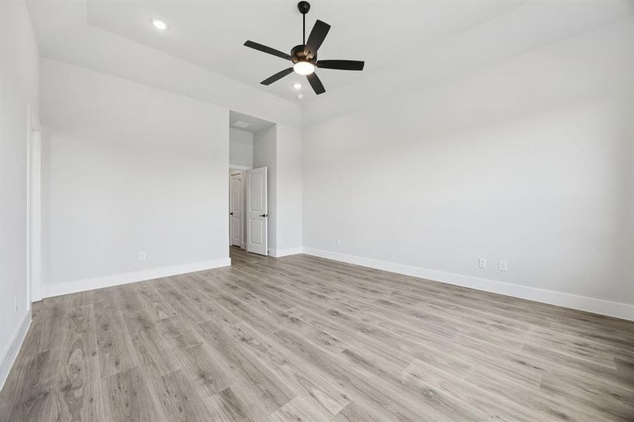 Spare room with light wood-type flooring, a ceiling fan, and recessed lighting