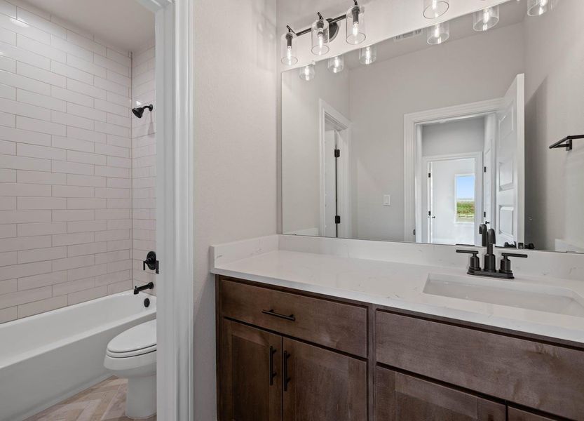 Bathroom featuring shower / bathing tub combination, vanity, and toilet Bathroom featuring shower / bathing tub combination, vanity, and toilet