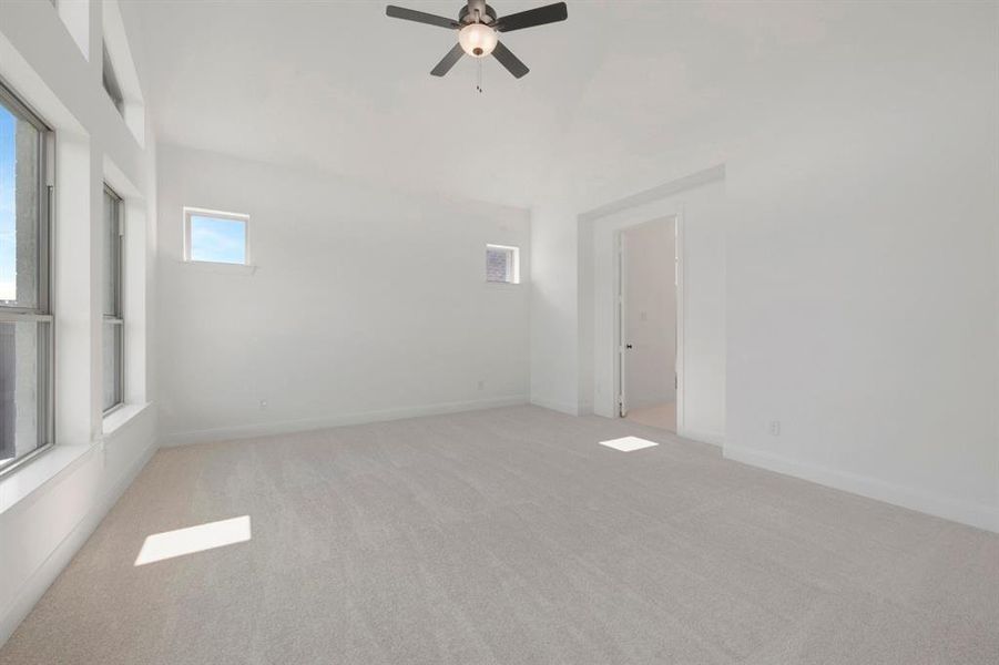 Bright room featuring an angled ceiling, light-toned carpeting, and multiple windows Bright room featuring an angled ceiling, light-toned carpeting, and multiple windows