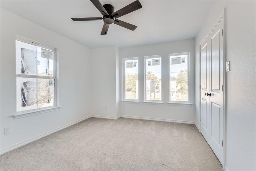 Carpeted spare room featuring ceiling fan