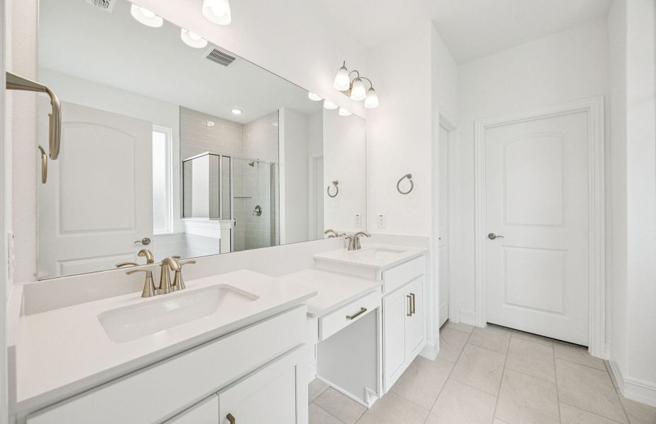 Luxurious owner's bath complete with double sinks and a generous shower  *Real home pictured