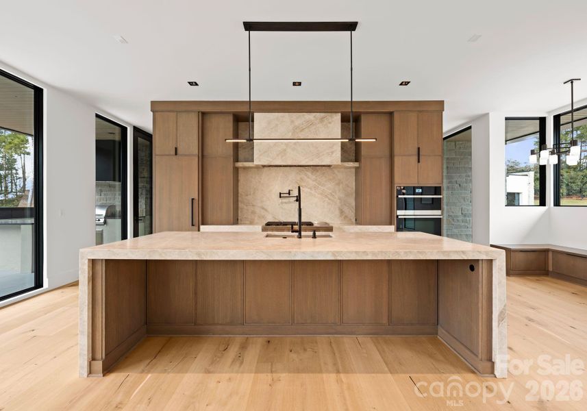 Kitchen featuring a waterfall island, custom cabinetry, and high-end appliances. Kitchen featuring a waterfall island, custom cabinetry, and high-end appliances.