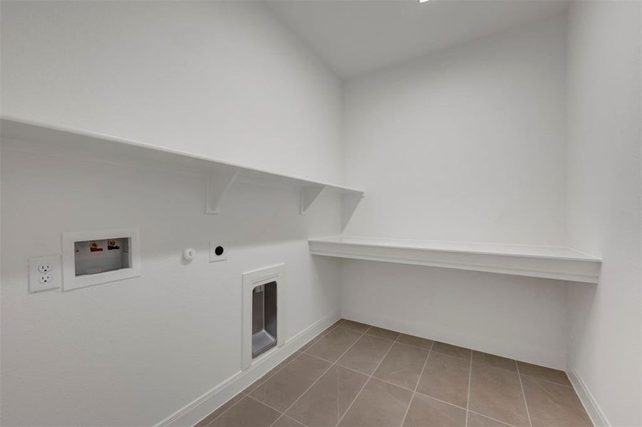 Laundry area featuring gas dryer hookup, light tile patterned floors, and washer hookup