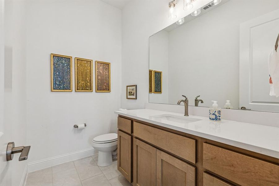 Half bath featuring vanity and light tile patterned floors