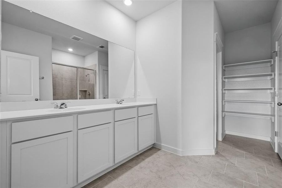 Bathroom with a shower stall, baseboards, double vanity, and recessed lighting Bathroom with a shower stall, baseboards, double vanity, and recessed lighting