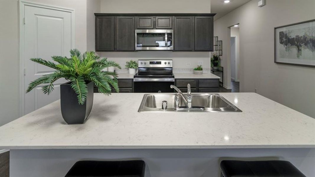 Kitchen island featuring a dual-basin stainless steel sink with a chrome faucet Kitchen island featuring a dual-basin stainless steel sink with a chrome faucet