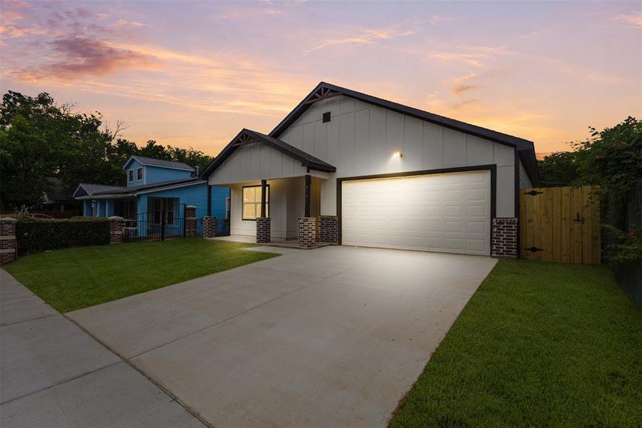 Modern farmhouse-style exterior with vertical siding, dark trim, a two-car garage, and a covered front entry