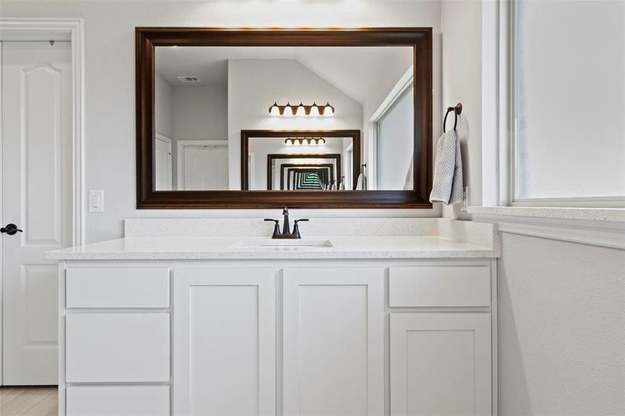 Bathroom with lofted ceiling and vanity