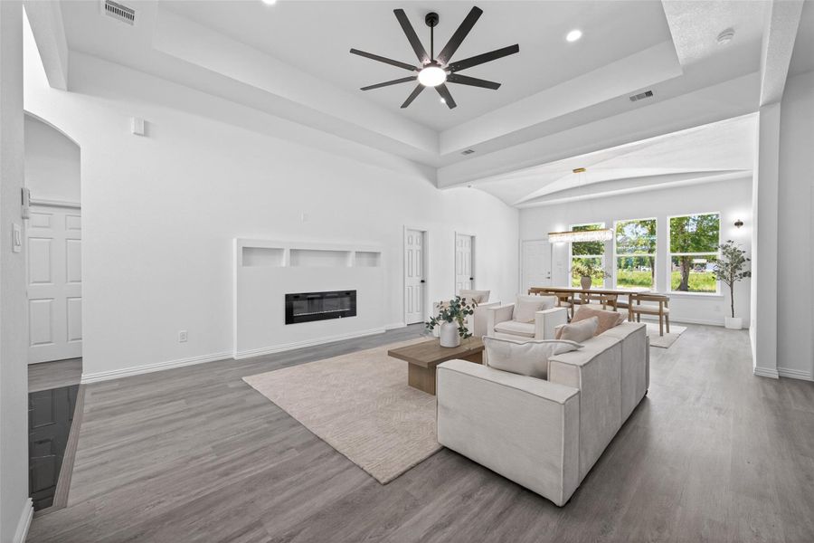 Bright and spacious open-concept living area featuring beautiful laminate flooring, abundant natural light, and custom finishes throughout.