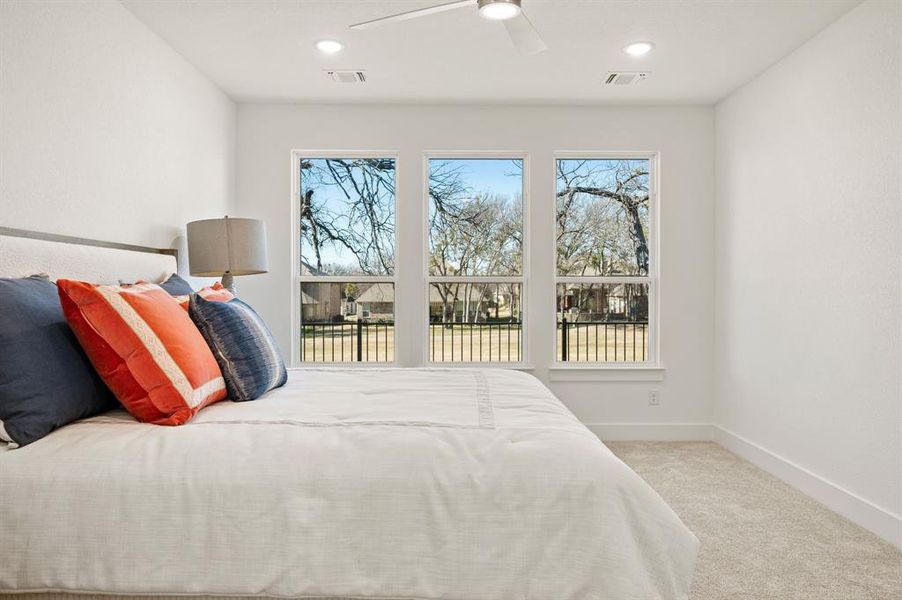 Bedroom with light colored carpet, ceiling fan, and recessed lighting
