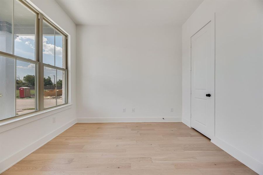 Unfurnished room with light wood-style flooring and baseboards Unfurnished room with light wood-style flooring and baseboards