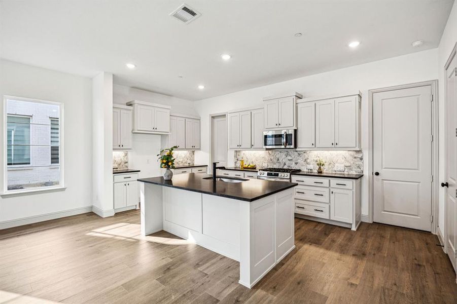 The spacious kitchen island is the perfect gathering place for friends and family. The spacious kitchen island is the perfect gathering place for friends and family.