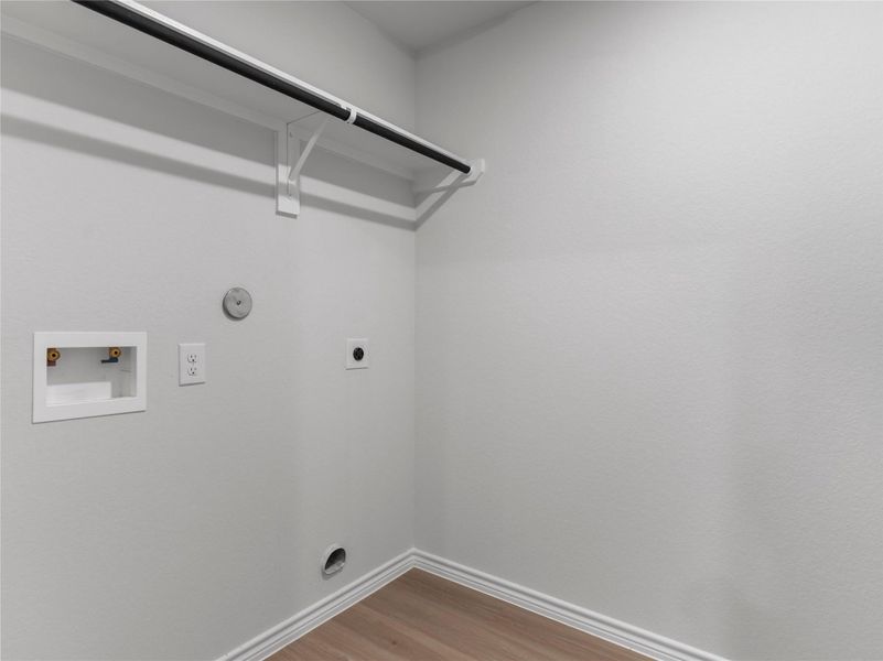 Spacious utility room with built-in shelves and washer/dryer hookups.