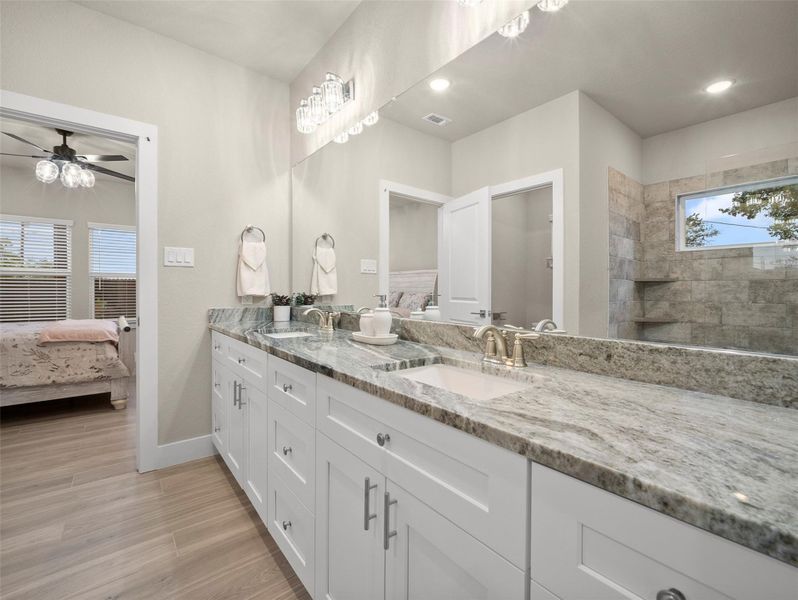 Ensuite bathroom featuring double vanity, light wood-type flooring, walk in shower, and ceiling fan Ensuite bathroom featuring double vanity, light wood-type flooring, walk in shower, and ceiling fan