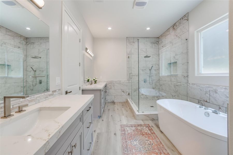 Bathroom with independent shower and bath, tile walls, hardwood / wood-style flooring, and vanity