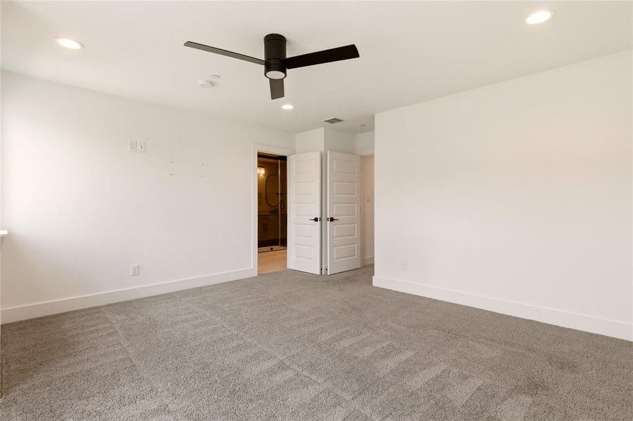 Unfurnished bedroom with light carpet, recessed lighting, ceiling fan, and ensuite bathroom