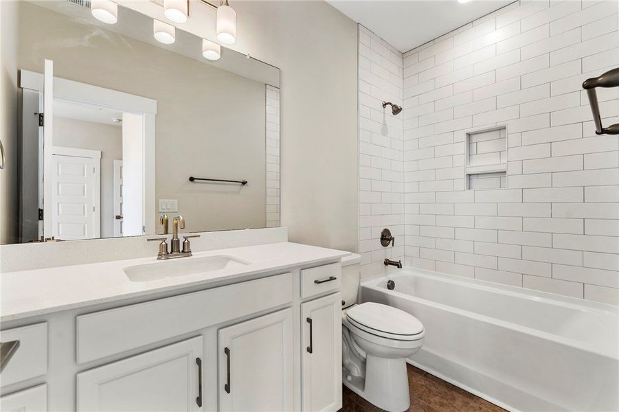 This bright bathroom features a clean vanity and a This bright bathroom features a clean vanity and a