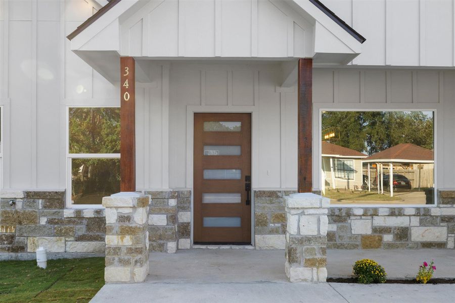Entrance to property featuring board and batten siding, stone siding, and a porch Entrance to property featuring board and batten siding, stone siding, and a porch
