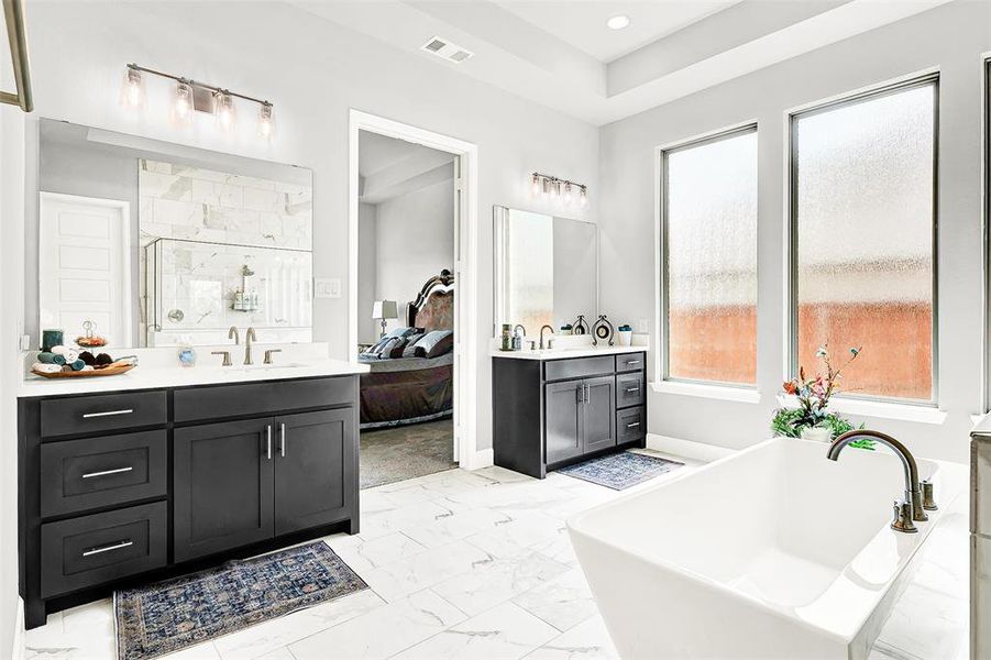 Bathroom with a shower stall, two vanities, light marble finish flooring, a freestanding tub, and connected bathroom Bathroom with a shower stall, two vanities, light marble finish flooring, a freestanding tub, and connected bathroom