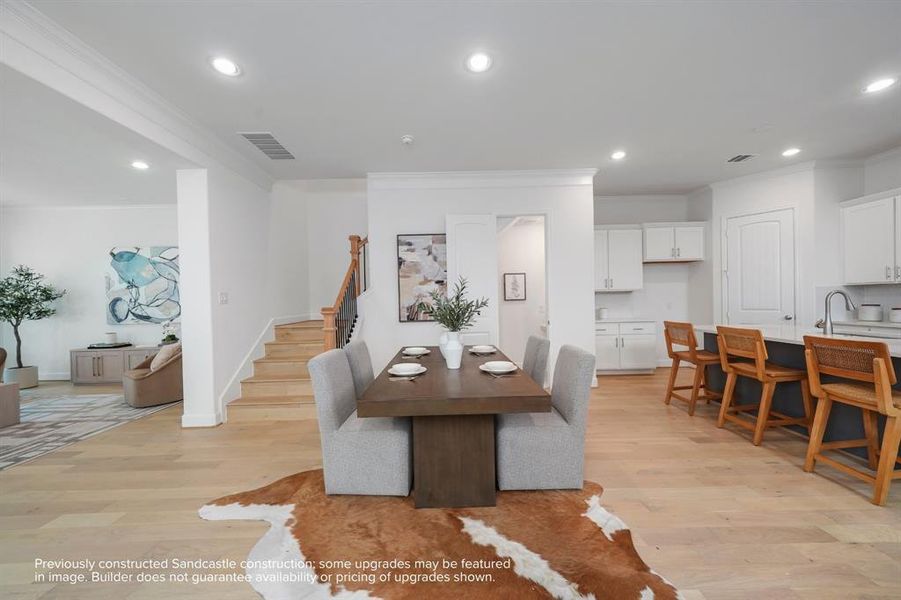 Elegant Ascension: The warm glow of wood floors not only grounds the dining room but also ascends, drawing the eye and spirit upward to the private sanctuaries above.