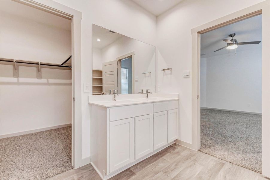 Enjoy seamless flow from the primary bedroom to this well-appointed en-suite bath. The double-sink vanity and oversized mirror are perfectly positioned between a walk-in closet and the bedroom, making your morning and evening routines effortlessly functional. Enjoy seamless flow from the primary bedroom to this well-appointed en-suite bath. The double-sink vanity and oversized mirror are perfectly positioned between a walk-in closet and the bedroom, making your morning and evening routines effortlessly functional.