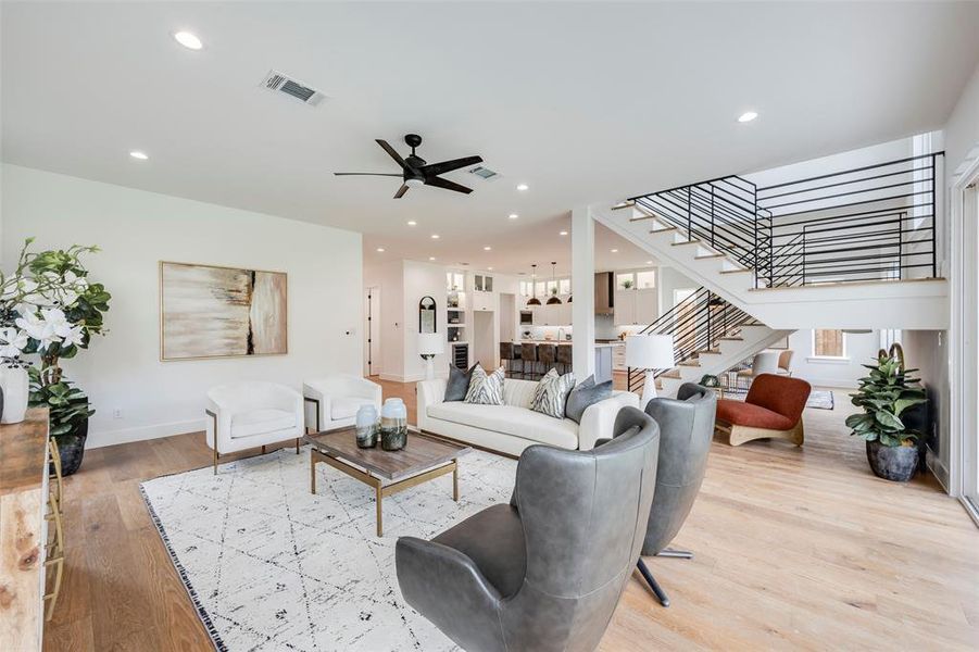 Living area with light wood-style flooring, recessed lighting, stairway, and a ceiling fan Living area with light wood-style flooring, recessed lighting, stairway, and a ceiling fan