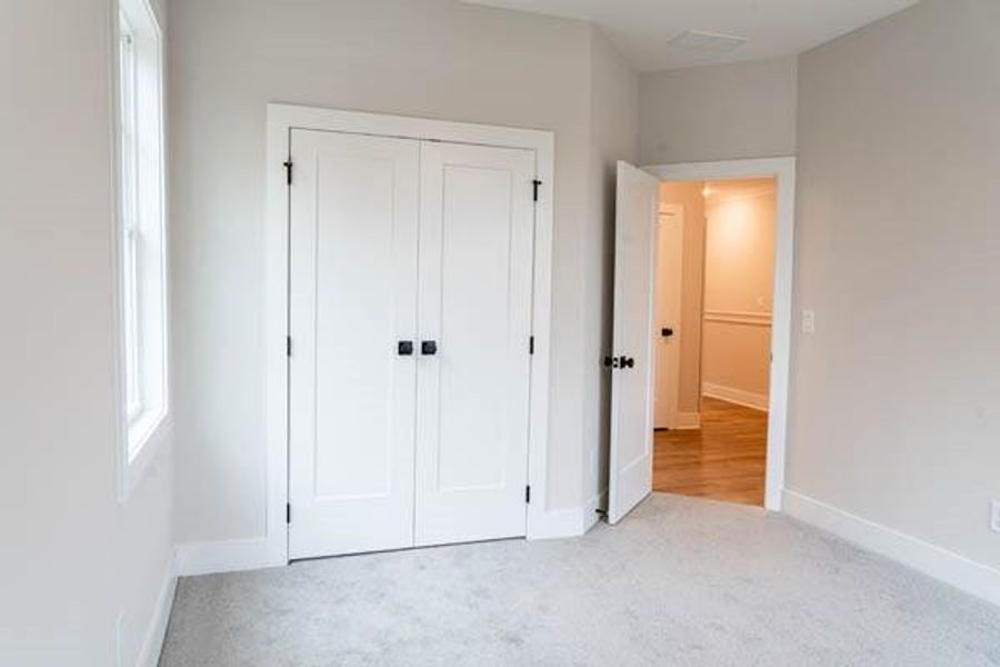 Unfurnished bedroom featuring light colored carpet and a closet Unfurnished bedroom featuring light colored carpet and a closet