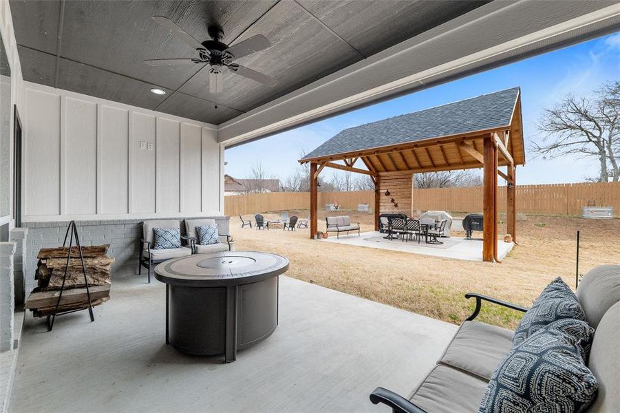 View of patio featuring a gazebo, an outdoor living space with a fire pit, and ceiling fan